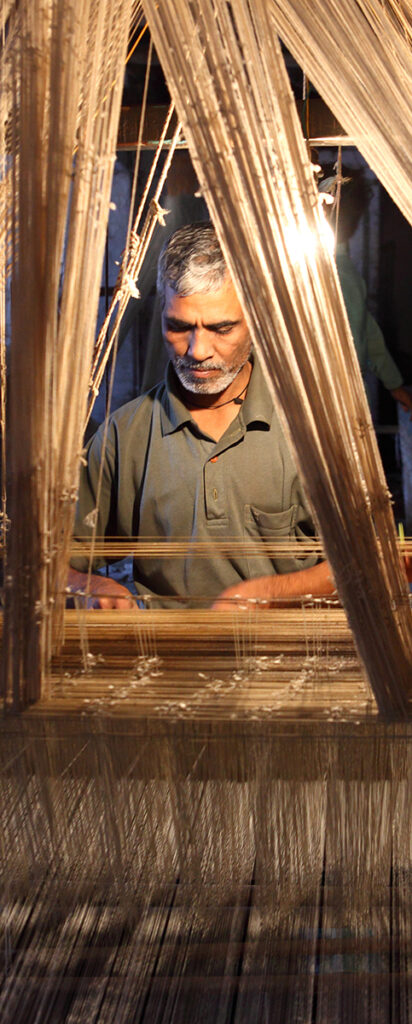 A weaver sits at work weaving a cloth. Varanassi is a major centre for the textile and handicraft industries.