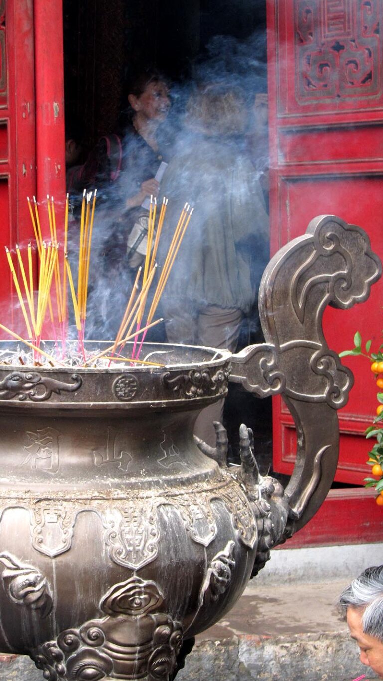 Burning incense outside the entrance to the Ngoc Son Temple, Hanoi
